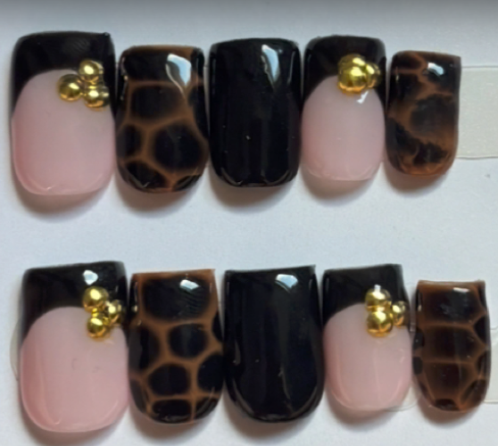 Black french tip nails with leopard print and gold charms